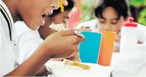  ??  ?? Estudiante­s de un colegio de Santo Tomás comen los almuerzos del PAE.