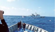  ?? AFP ?? Continued faceoff: A Chinese Coast Guard ship manoeuvrin­g past a Philippine vessel in the disputed South China Sea.