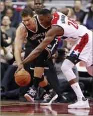  ?? ALEX BRANDON — ASSOCIATED PRESS ?? Wizards center Ian Mahinmi, right, steals the ball from Nets center Brook Lopez during Washington victory over Brooklyn.