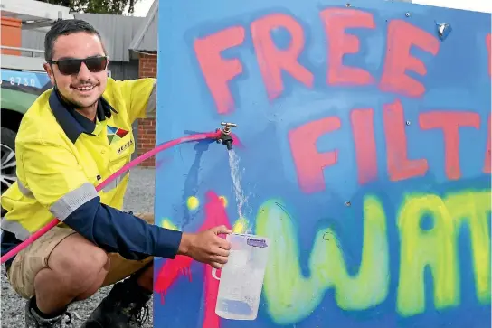  ?? PHOTO: JOHN BISSET/STUFF ?? Plumbing apprentice Logan Kirke fills up a jug with the tap, stationed out front of the Temuka business on King St.