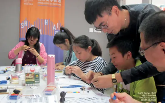  ??  ?? Lang Jiaziyu (third right) teaches children to make dough figurines