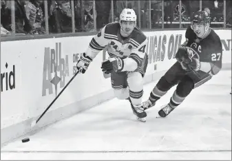  ?? [BEBETO MATTHEWS/THE ASSOCIATED PRESS] ?? The Rangers’ Chris Kreider, left, beats the Islanders’ Anders Lee to the puck during Saturday’s game in New York.