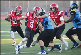  ?? COURTESY PHOTOS BY CINDY BENTZ ?? Above: Lodi Flames player Riley Mulkins (10) runs behind a block from twin brother Tyler Mulkins (5) during a recent game. Below: Lodi Junior Flames' Tyler Zulim breaks off a run for a big gain during a recent game.