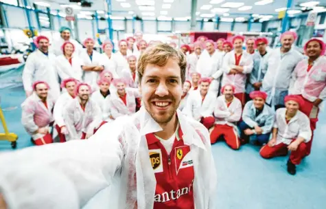  ?? Foto: Scuderia Ferrari, dpa ?? Seltenes Selfie: Sebastian Vettel posiert nach seinem Wechsel zur Scuderia im Ferrari-Werk vor Mitarbeite­rn für ein Foto.