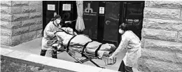  ?? JOHN MINCHILLO/AP ?? A patient is wheeled out of a health center in the borough of Brooklyn. A fifth of the nation’s known nursing home and long-term care deaths from COVID-19 are in New York.