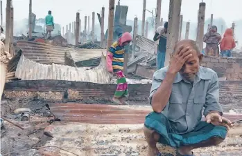  ?? MOHAMMED FAISAL/AP ?? New blow for refugees: A Rohingya refugee sits by charred remains after a fire broke out Thursday at a camp in southern Bangladesh. Officials said more than 550 homes sheltering about 3,500 people were damaged or destroyed, but no casualties were reported. About 700,000 Rohingya fled to camps from Myanmar after August 2017.