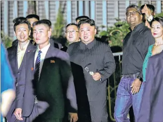  ?? AP PHOTO ?? North Korea leader Kim Jong Un, centre, is escorted by his security delegation as he visits Marina Bay in Singapore, Monday, ahead of Kim’s summit with U.S. President Donald Trump.