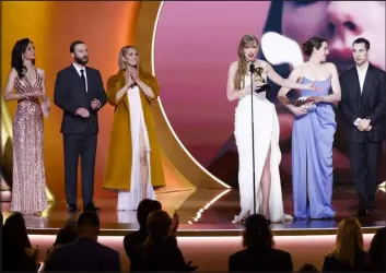  ?? Sonja Flemming Tribune News Service ?? Taylor Swift accepts album of the year Sunday at the Grammy Awards after appearing to barely make eye contact with the award’s presenter, Celine Dion, third from left.