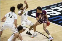  ??  ?? Texas Southern’s Jordan Gilliam (11) dribbles behind his back to move around Michigan’s Mike Smith (12) and Brandon Johns Jr. (23) during the second half Saturday in West Lafayette, Ind.