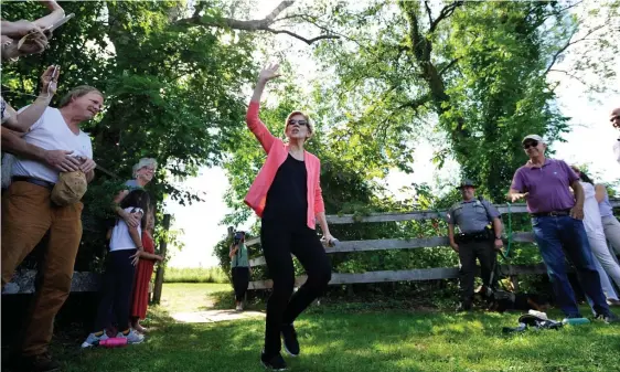  ?? GETTY IMAGES ?? TWEET DRAWS HEAT: Massachuse­tts Sen. Elizabeth Warren, shown campaignin­g for president in Franconia, N.H., has received criticism for her tweet saying ‘Michael Brown was murdered by a white police officer.’ Below, SWAT officers work at the scene where six Philadelph­ia police officers were shot Wednesday.