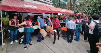  ?? ?? VECINOS hacen fila para tomar garrafones del gobierno, ayer.