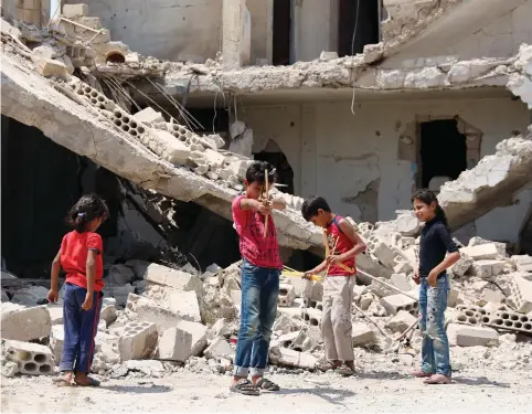  ??  ?? CHILDREN AT play in a rebel-held part of the Syrian city of Deraa on Sunday.