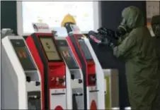  ?? DANIEL CHAN - THE ASSOCIATED PRESS ?? A hazmat crew scan the check in kiosk machines at Kuala Lumpur Internatio­nal Airport 2 in Sepang, Malaysia. Malaysian police ordered a sweep of Kuala Lumpur airport for toxic chemicals and other hazardous substances following the killing of Kim Jong Nam.