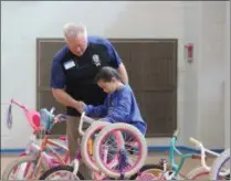  ?? CHARLES PRITCHARD — ONEIDA DAILY DISPATCH ?? Volunteer Perry Tooker III helps a child find the bike best for her at Community Bikes’ Bike Day on Sunday, May 5.