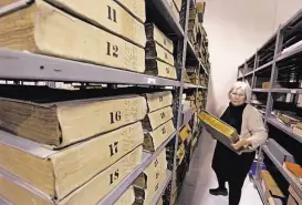  ?? Steve Gonzales / Houston Chronicle ?? Sarah Canby Jackson of the Harris County Archives pulls a 1997 Block Book, which might benefit from a $2 to 3 million restoratio­n project funded by records fees.