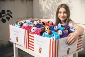  ?? Santiago Mejia / The Chronicle ?? Sadie Cinader, 13, with kits for kids who have lost loved ones in the pandemic. Each kit has a stuffed animal, stress ball, journal, pen, poetry and a nice note.