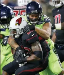  ?? ROSS D. FRANKLIN — THE ASSOCIATED PRESS ?? Arizona’s Adrian Peterson (23) is stopped by Seattle defensive end Michael Bennett during the first half Thursday in Glendale, Ariz.