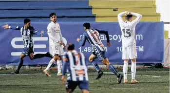  ?? /EFE. ?? Mientras Juanan Casanova (der.) corre para festejar el segundo gol del modesto Alcoyano, los jugadores del Real Madrid se lamentan incrédulos ante su eliminació­n.