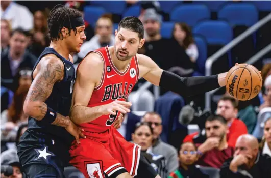  ?? KEVIN KOLCZYNSKI/AP ?? Bulls center Nikola Vucevic, guarded by Magic rookie forward Paolo Banchero, had 26 points and 13 rebounds Saturday night.