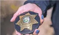  ??  ?? Lt. Samantha Yazzie with the Navajo Nation Department of Criminal Investigat­ion displays her badge earlier this month in Window Rock, Ariz.