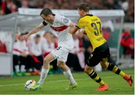  ?? — AP ?? Stuttgart’s Kevin Grosskreut­z ( left) and Erik Durm of Borussia Dortmund vie for the ball in their German Cup quarter- final at the Mercedes Benz Arena in Stuttgart on Tuesday. Dortmund won 3- 1.