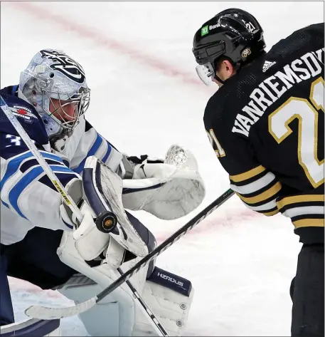  ?? MATT STONE — BOSTON HERALD ?? James van Riemsdyk #21 of the Boston Bruins tries to get the puck past Connor Hellebuyck #37 of the Winnipeg Jets during the second period at the Garden.