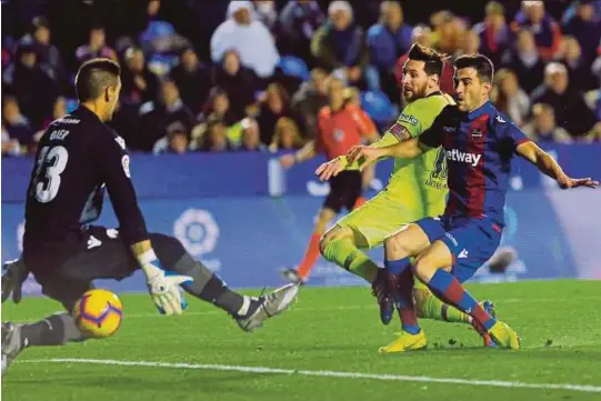  ?? [ FOTO REUTERS ] ?? Messi menjaringk­an gol kedua Barcelona dengan membenam Levante 5-0 bagi mendahului liga dengan perbezaan tiga mata, kelmari.