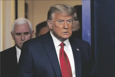  ?? ASSOCIATED PRESS ?? PRESIDENT DONALD TRUMP, followed by Vice President Mike Pence (left) walks into the briefing room at the White House in Washington on Tuesday to make a statement.