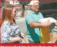  ??  ?? Neiva Souza e Ricardo Peres são clientes fiéis dos carros. ‘São mais baratos. No supermerca­do, a dúzia custa R$ 6’, diz ela