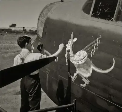  ??  ?? No. 460 Squadron navigator and artist Vic Watts in the process of painting the nose art on Lancaster W5005 at Binbrook in July 1943, when the aircraft had completed 12 ops. (Photo courtesy of Robyn Jackson, via Richard Munro, 460 Sqn. Veterans and Friends Group, restored by John Dibbs)