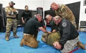  ?? Kin Man Hui / Staff photograph­er ?? Instructor Joshua Thomas, center, oversees Bexar County Sheriff ’s Office deputies as they practice a restraint technique developed by a retired S.A. officer.