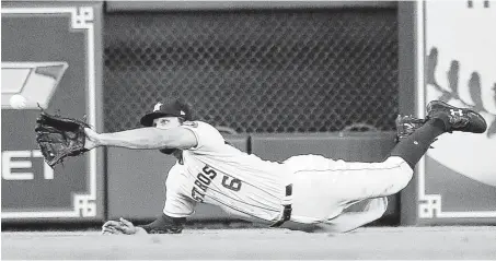  ?? Karen Warren / Staff photograph­er ?? Center fielder Jake Marisnick does his best to preserve the Astros’ 1-0 lead in the eighth, making a second diving catch in the inning to rob the Mariners’ Robinson Cano before Daniel Vogelbach hit a grand slam for Seattle.