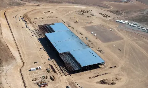  ?? (James Glover II/Reuters) ?? THE TESLA GIGAFACTOR­Y is shown under constructi­on outside Reno, Nevada, in 2015. Electric-car maker Tesla has received a top AAA score from MSCI but a middling grade from Sustainaly­tics, below that of traditiona­l automakers Ford Motor Co. and General...