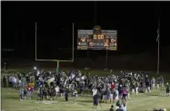  ?? RICH PEDRONCELL­I — THE ASSOCIATED PRESS ?? Players and fans of Paradise High School mill on the field after defeating Williams High School, 42-0, in Paradise, Calif., on Aug. 23.