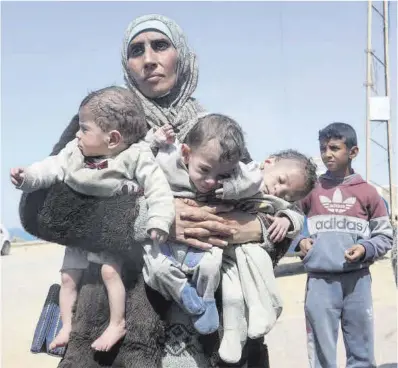  ?? Ramadan Abed / Reuters ?? Una mujer carga con sus tres hijos ayer, en Gaza.