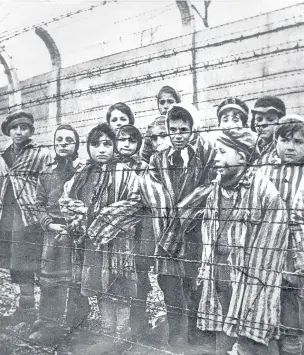  ??  ?? Children behind a barbed wire fence at the infamous Nazi concentrat­ion camp at Auschwitz-Birkenau in southern Poland