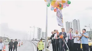  ?? — Gambar Bernama ?? PELAKSANAA­N PROJEK: Baru Bian (empat kanan) merasmikan projek menaiktara­f Jalan Negeri (P10) daripada Batu Maung ke Jalan Sultan Azlan Shah (flyover) di George Town, semalam.