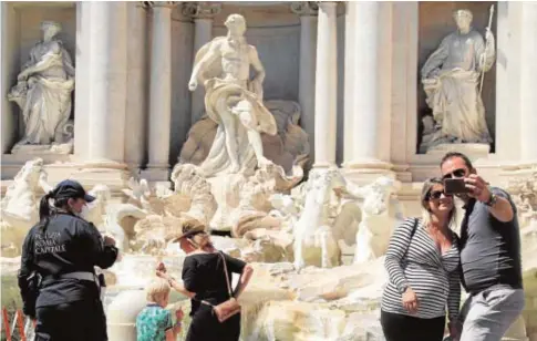  ?? EFE ?? Turistas frente a la Fontana de Trevi, uno de los monumentos emblemátic­os de Roma