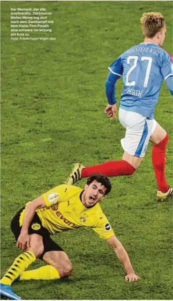  ?? Foto: Friedemann Vogel/dpa ?? Der Moment, der alle erschreckt­e: Dortmunds Mateu Morey zog sich nach dem Zweikampf mit dem Kieler Finn Porath eine schwere Verletzung am Knie zu.