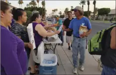  ?? JULIO MORALES PHOTO ?? Calexico Brown Bag volunteers hand out meals to the area’s homeless population in July 2017 in front of City Hall.