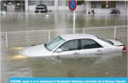  ??  ?? KURUME, Japan: A car is submerged in floodwater­s following a torrential rain in Kurume, Fukuoka prefecture. — AFP
