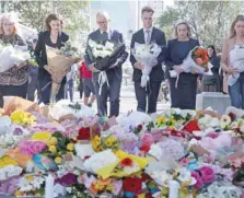  ?? — AFP ?? Australian PM Anthony Albanese (C) stands with officials as they prepare to leave flowers outside the Westfield Bondi shopping mall in Sydney.