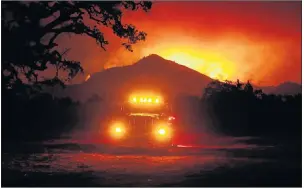  ??  ?? Flames rise from a hillside east of Santa Rosa, Calif., Tuesday as wildfires, whipped by powerful winds, swept through Northern California.