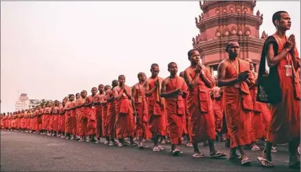  ?? RAPHAEL PECH ?? A procession of Buddhist monks pass Independen­ce Monument in February 2024.