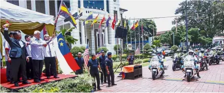  ??  ?? Riding against corruption: Mohd Khalil (holding the Melaka flag) flanked by Idris (left) and Dzulkifli preparing to flag off the Kejar ‘17 convoy at the Proclamati­on of Independen­ce Memorial in Banda Hilir.