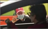  ??  ?? Monsignor James Treston waves to well-wishers as they drive by St. Catharine of Siena Catholic Church in Exeter Township on the afternoon of May 14 to congratula­te him for 60years in the priesthood.