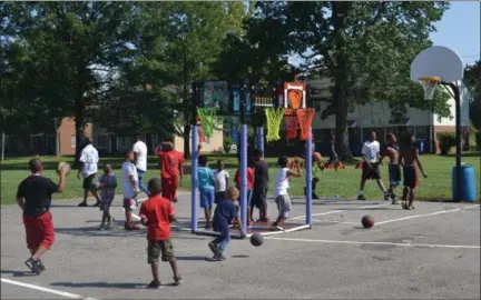  ?? KEITH REYNOLDS — THE MORNING JOURNAL ?? Children playing basketball on a 2ONEHOOP Aug. 19 at the Lorain Junior Olympics at Leavitt Homes. The hoops, invented by Stacey Charlton of Lorain, have television screens in the backboard.