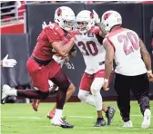  ??  ?? Cardinals running back David Johnson (31) looks for room to run during Saturday’s practice.