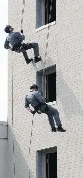  ?? NICK BRANCACCIO ?? Windsor Police Constables Al Frederick Jr., left, and Ryan Breault rapel from the top of a four-storey training structure as hundreds of schoolchil­dren watch. Officers involved in the VIP program visited schools throughout the year to talk with students.