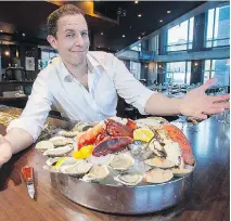  ??  ?? Daniel (Mr. Shucker) Notkin, owner of Notkins restaurant, shows off a generous shellfish platter complete with lobster.
